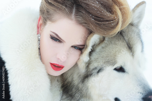 Young woman with wolf dog in snow © Misha