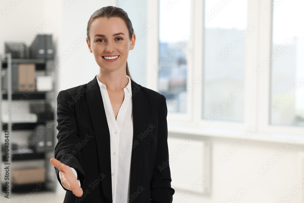Happy woman welcoming and offering handshake in office, space for text Happy woman welcoming and offering handshake in office, space for text