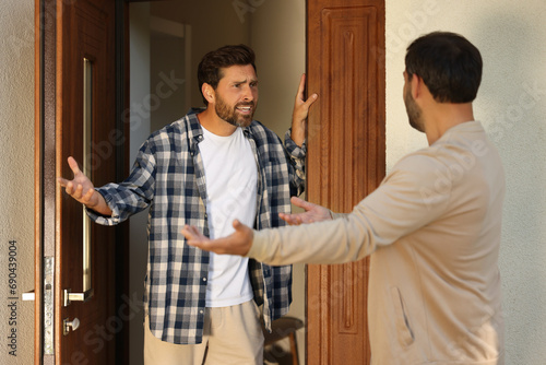 Emotional neighbours having argument near house outdoors