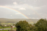 rainbow arching over houses in the valley