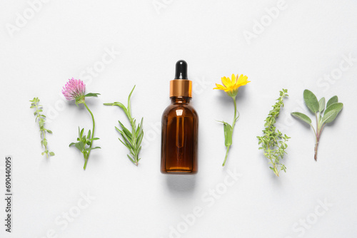Wallpaper Mural Bottle of essential oil, different herbs and flowers on white background, flat lay Torontodigital.ca