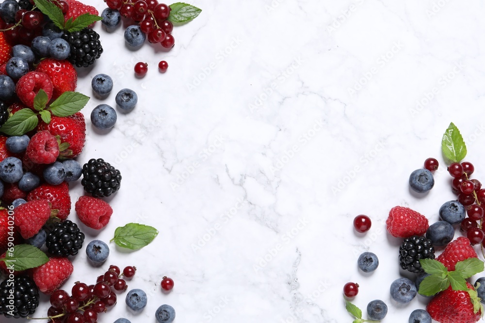 Many different fresh ripe berries on white marble table, flat lay. Space for text Many different fresh ripe berries on white marble table, flat lay. Space for text