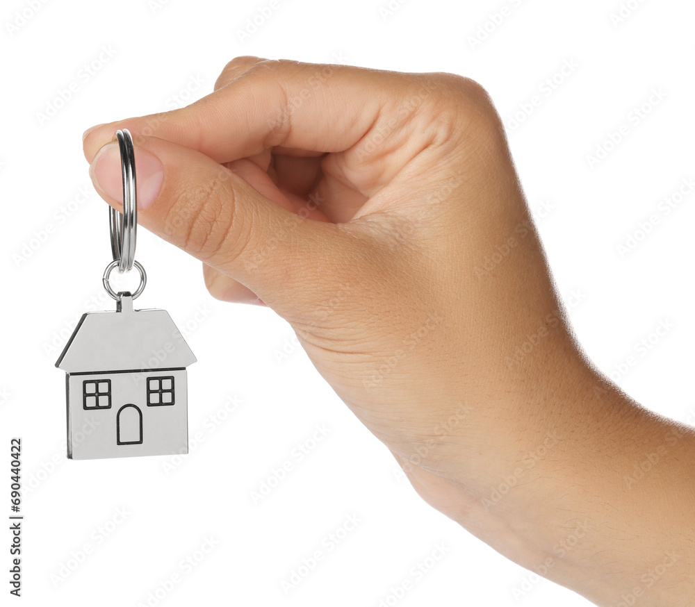 Woman holding metallic keychain in shape of house on white background, closeup Woman holding metallic keychain in shape of house on white background, closeup