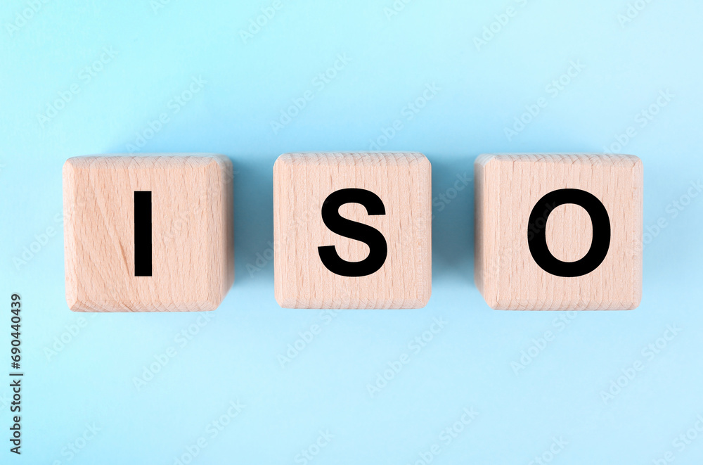 International Organization for Standardization. Wooden cubes with abbreviation ISO on light blue background, top view