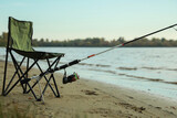 Folding chair and fishing rod at riverside