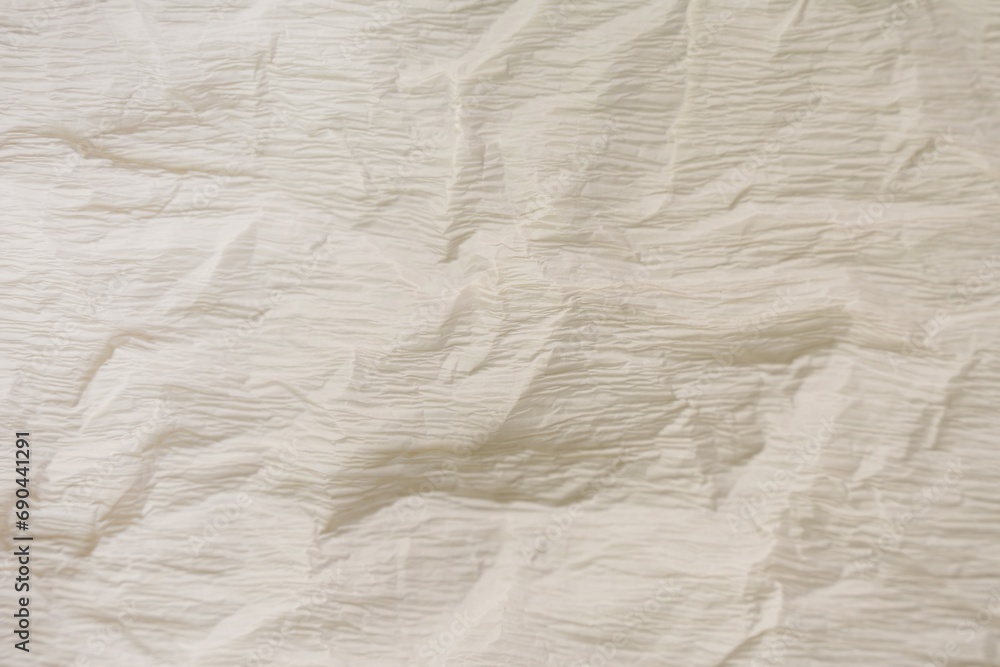 Obraz premium Texture of crumpled beige paper as background, closeup view