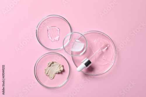 Pipette, cosmetic serum and petri dishes with samples on pink background, flat lay