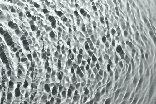 Rippled surface of clear water on light grey background, top view