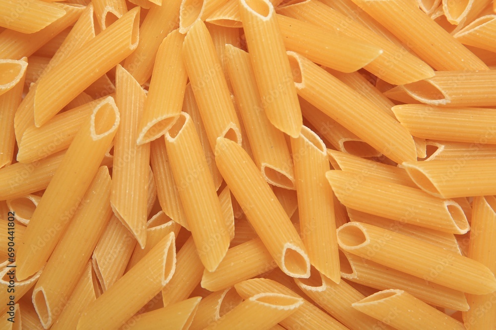 Uncooked penne pasta as background, top view Uncooked penne pasta as background, top view