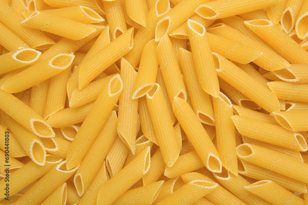 Uncooked penne pasta as background, top view Uncooked penne pasta as background, top view