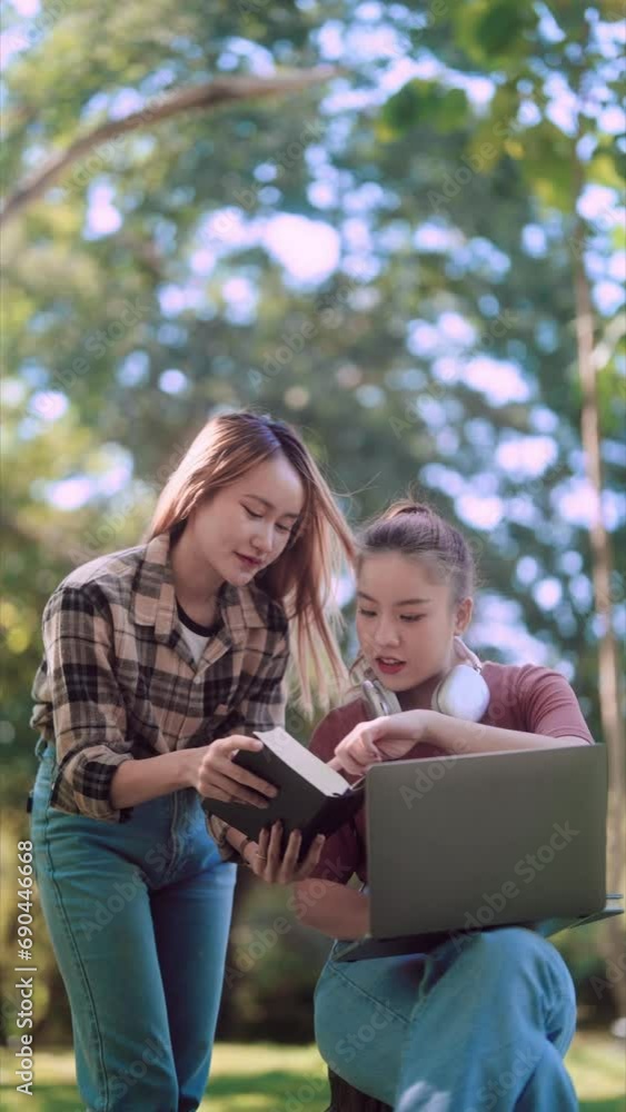 Asian female college student and her friends studying and researching content using laptops and textbooks under the trees in a garden, creating a refreshing outdoor study environment Asian female college student and her friends studying and researching content using laptops and textbooks under the trees in a garden, creating a refreshing outdoor study environment