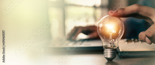 Hand choose light bulb with bright for creative idea concept or innovation of technology in analyzing global marketing online business data management services to target growth concept.