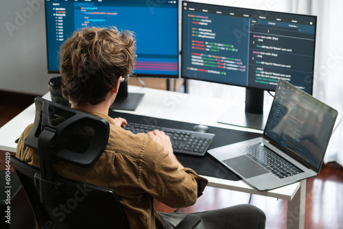 IT developer working online software development on pc monitors at modern home office on coding application screens, creating updated latest program firmware information version concept. Gusher. photo