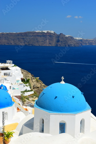 Fototapeta Naklejka Na Ścianę i Meble -  SANTORINI,GREECE-June 20 2023: Oia village, the most picturesque village on Santorini island, a famous touristic resort in the Cyclades islands, Aegean sea, Greece, Europe. This was on a hot sunny day