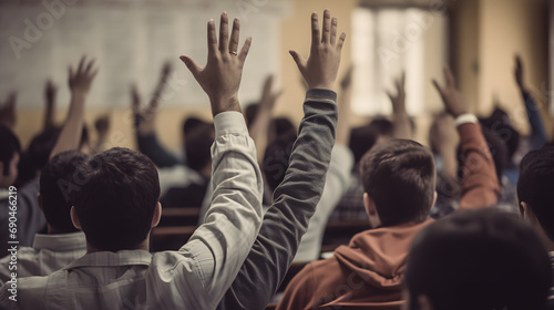 Students raise their hands to answer the teacher's questions in the classroom, many students raise their hands, back view image. photo