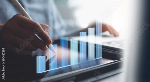 Business analytics and financial technology concept. Businessman analyzing financial graph growth chart, using digital tablet, working at office, business and financial background