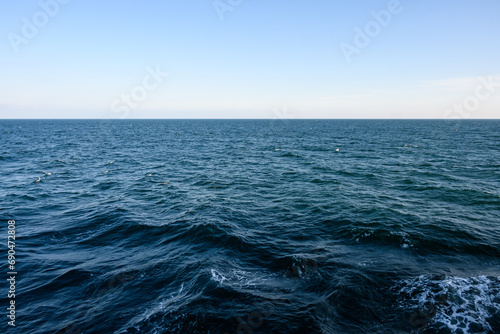 Calm and peaceful nature background, arctic ocean to the horizon of early morning light blue sky 