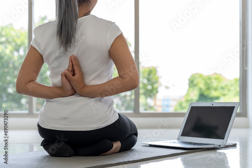 Online Yoga Tutorial: Young Woman Practices Yoga at Home
