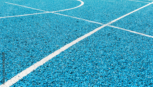 Light blue rubberized and granulated ground surface with white lines photo