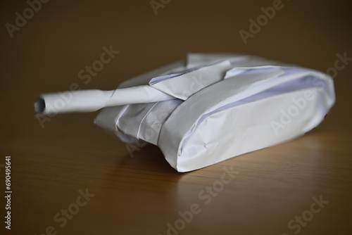 Beautiful isolated close up image of an origami model made with white paper of a single battle tank © Oren
