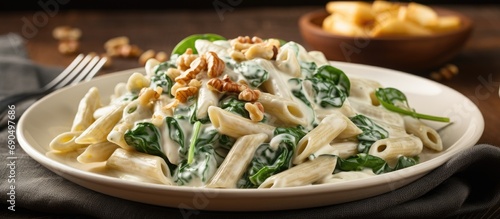 Healthy whole wheat pasta with gorgonzola sauce, spinach, and walnuts. photo