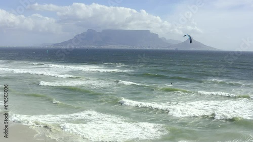 Kite surfing, beach and aerial of people in ocean for adventure on holiday, vacation and travel. Nature, tourism and drone view of surfer on waves for water sports, hobby and fun in South Africa