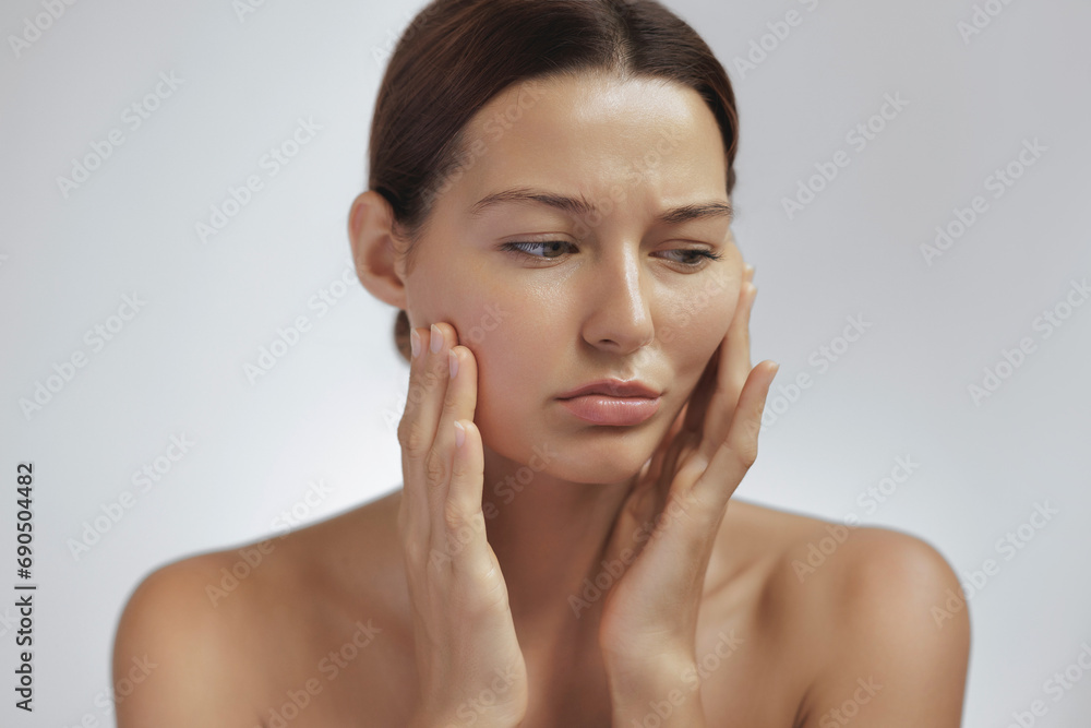 Concept photo of aging. Checking of face skin. Portrait of a worried Asian woman. Beauty treatments and lifting. passing youth. Aging and rejuvenation process. High-quality photo Concept photo of aging. Checking of face skin. Portrait of a worried Asian woman. Beauty treatments and lifting. passing youth. Aging and rejuvenation process. High-quality photo