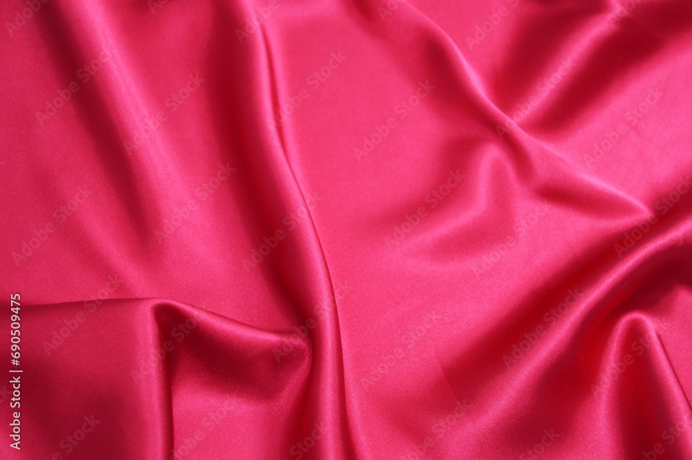Bright red satin or silk fabric with soft folds. Background. Bright red satin or silk fabric with soft folds. Background.
