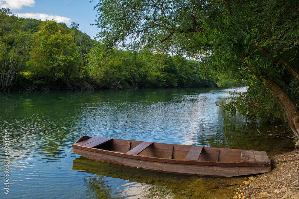 A wooden boat on the River Una north of Martin Brod, Bihac, in the Una National Park. Una-Sana Canton, Federation of Bosnia and Herzegovina. Early September