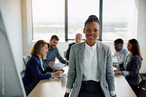 Happy black businesswoman during meeting in office looking at camera.