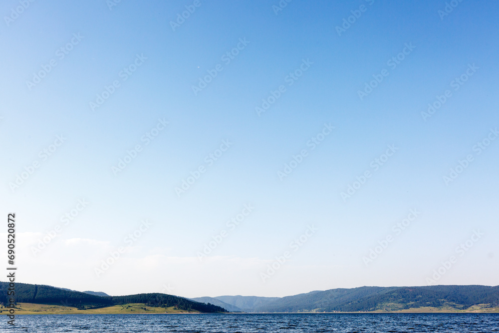 Fototapeta premium Landscape with lake, hills and empty sky
