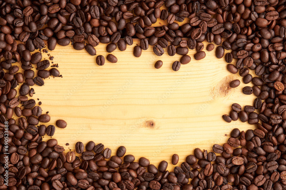 Top view of roasted coffee beans texture background on flat lay in horizontal with wooden board free space in center. pattern for design menu drink. coffee beans frame. Top view of roasted coffee beans texture background on flat lay in horizontal with wooden board free space in center. pattern for design menu drink. coffee beans frame.