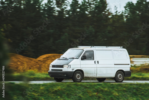 Banner image of white modern delivery shipment cargo courier van moving fast on the highway road to city and urban suburb. Small bus driving on highway day. Business of distribution and logistics photo