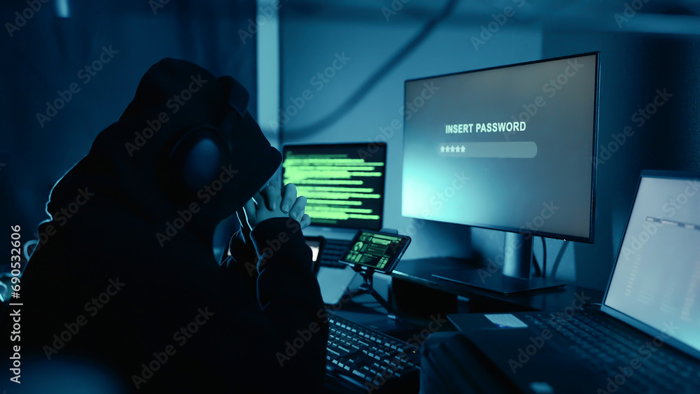A dangerous hacker in hood thinking security password for login breaks into company data servers in dark atmosphere. Security password login technology business concept. Hacker concept A dangerous hacker in hood thinking security password for login breaks into company data servers in dark atmosphere. Security password login technology business concept. Hacker concept