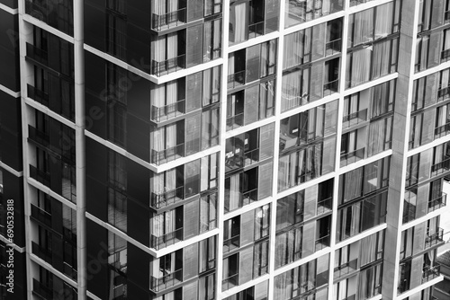 Window residential building apartment. Modern city skyscraper in day light. Apartment windows in modern skylines with day light with monochrome filter. Real estate. Closeup. Side view. Ornamented.