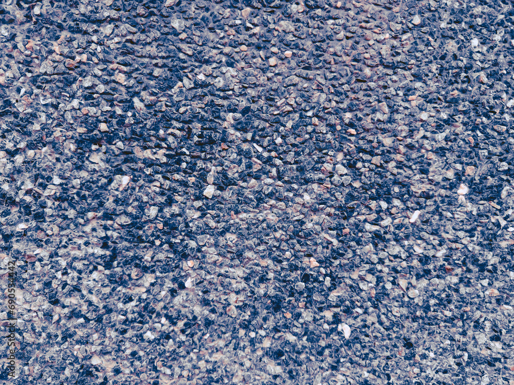 Close-up shot of a textured surface made up of small pebbles in various shades of blue, gray, and pink. Captured from a top-down perspective. Close-up shot of a textured surface made up of small pebbles in various shades of blue, gray, and pink. Captured from a top-down perspective.
