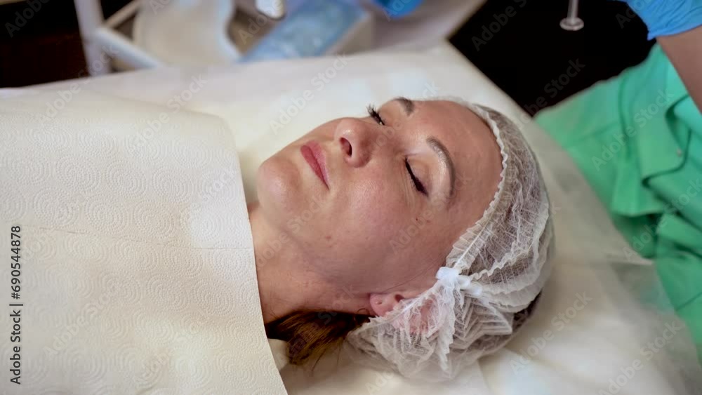 Middle aged woman waiting for mesotherapy beauty treatment in beauty salon lying on medical couche. Professional moisturizing and rejuvenating medical procedures for modern people Middle aged woman waiting for mesotherapy beauty treatment in beauty salon lying on medical couche. Professional moisturizing and rejuvenating medical procedures for modern people