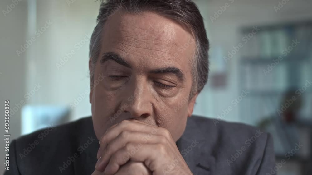 Close up of tired aged man in business suit thinking about working issues at office Close up of tired aged man in business suit thinking about working issues at office