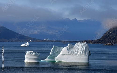 close up of icebergs and  mountain peaks,  near nanortalik near tasermiut fjord  in southern greenland, on a  cruise ship in summer photo