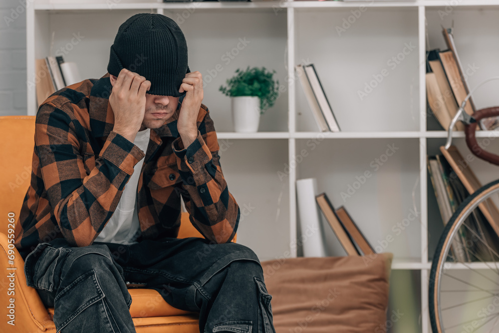 young man at home in winter stressed