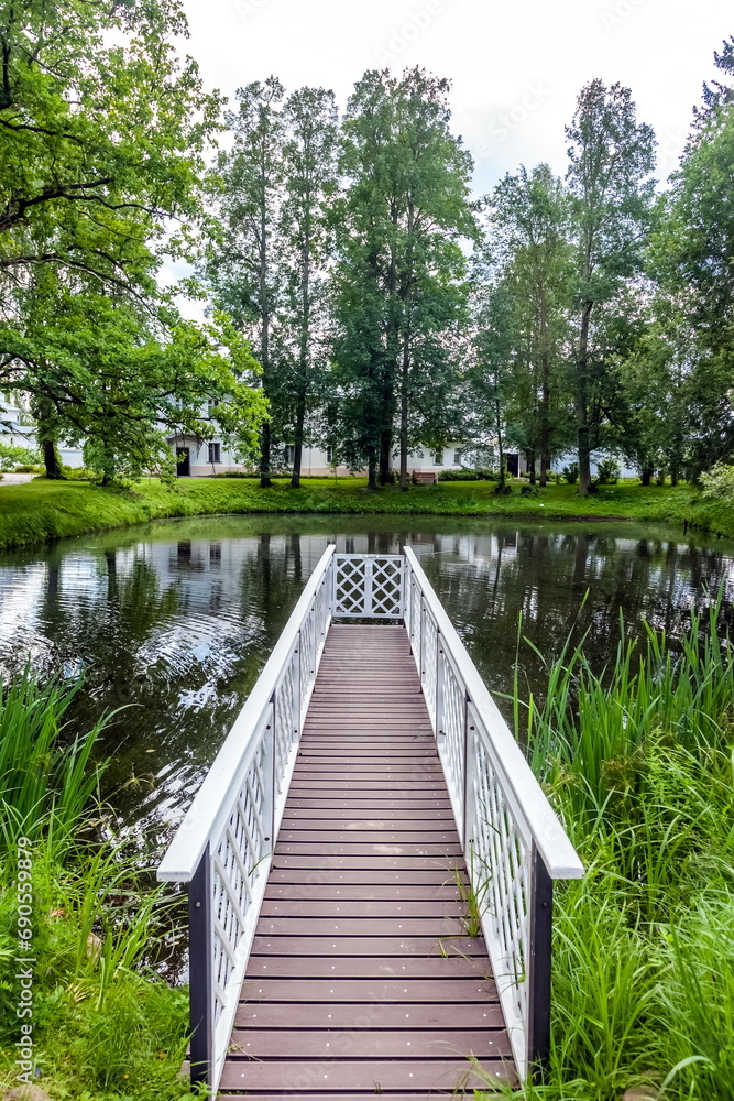 Wooden bridge on a small artificial lake in summer Wooden bridge on a small artificial lake in summer