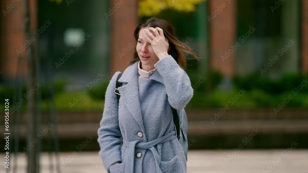 joyful middle-aged woman in coat walking alone in city street in autumn day, portrait in downtown joyful middle-aged woman in coat walking alone in city street in autumn day, portrait in downtown