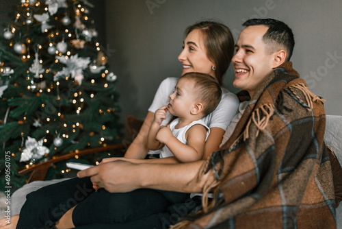 Fotografie A family of young parents and son cherishes moments together over Christmas holidays