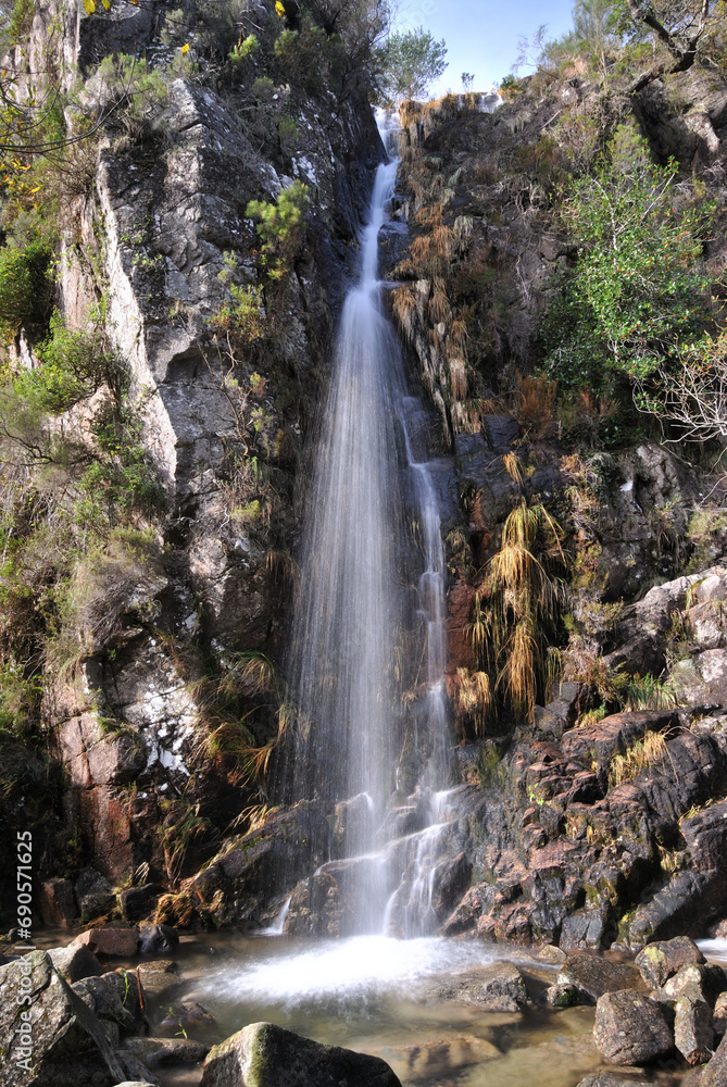 Obraz premium Beautiful waterfall on a mountain, with a small lagoon below, Gerês, Portugal