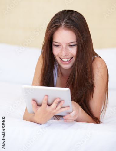 Woman, tablet and relax on bed with internet, social media or online streaming service for film choice or movies. Happy young person reading or watch on her digital technology in a bedroom or at home