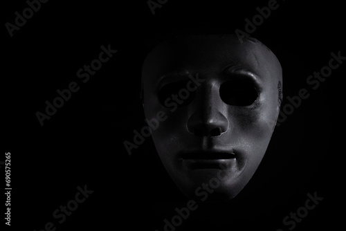 Criminal disguise, black mask on a dark background, theatrical crime