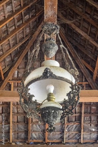 an antique Mojopahit chandelier hanging from the wooden roof photo