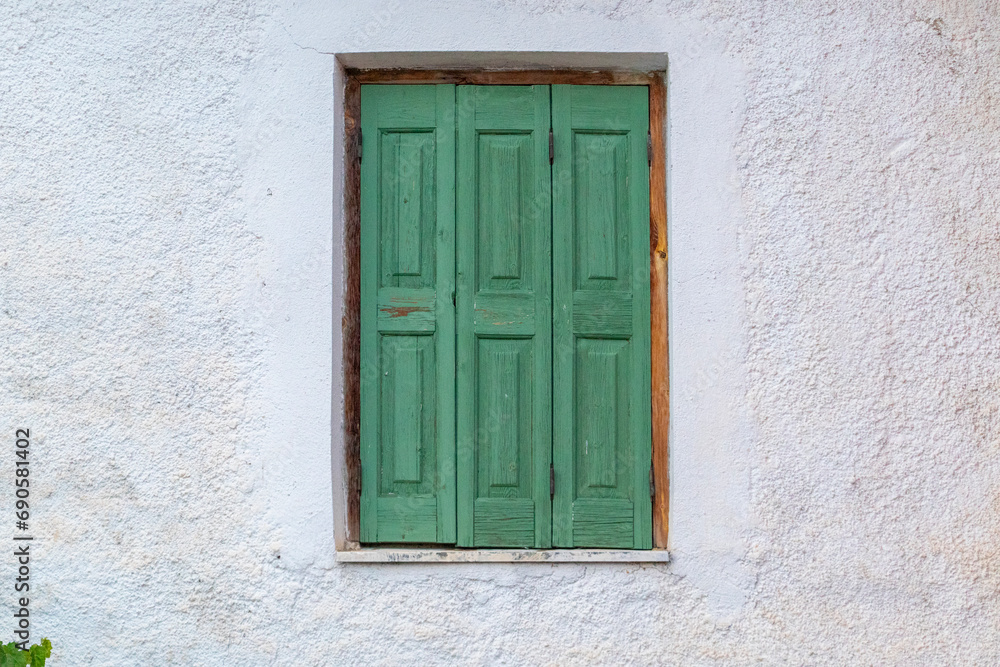 Green window on a white wall