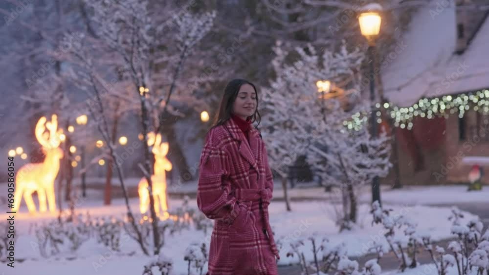 Beautiful caucasian woman in festive mood walking near idyllic house decorated with lights and garlands with snow in the background. Magical fairytale winter season Beautiful caucasian woman in festive mood walking near idyllic house decorated with lights and garlands with snow in the background. Magical fairytale winter season