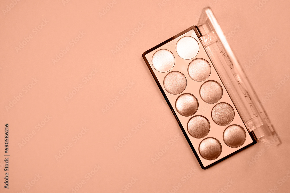 Makeup palette with sparkling eyeshadows on a beige background. Flat lay, place for text. Trendy color of year 2024 - Peach Fuzz. Makeup palette with sparkling eyeshadows on a beige background. Flat lay, place for text. Trendy color of year 2024 - Peach Fuzz.